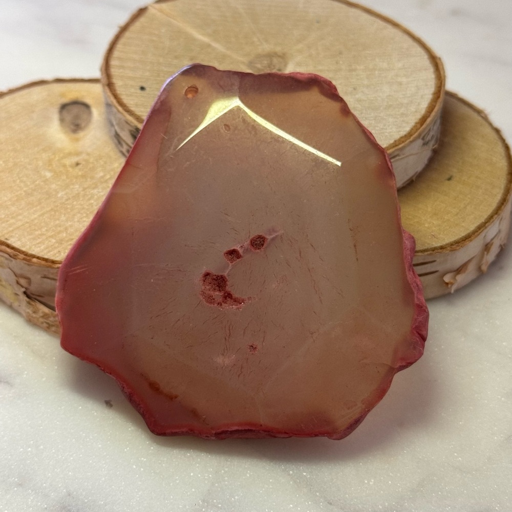 Pink agate slices with a predrilled hole, perfect for jewelry making and crafts.